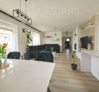 Interior of a family house with a wooden decor floor, dining table, and sofa.