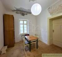 A dining room in a family house with a simple table and a wooden decor floor.