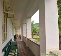 A veranda with a bench at a family house in Dobroč, overlooking the garden and trees.