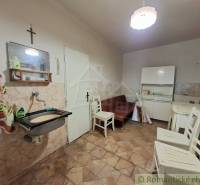 Interior of a family house with a tiled wall, furniture, and a sink.