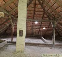 Attic in a family house with wooden beams and a brick roof.
