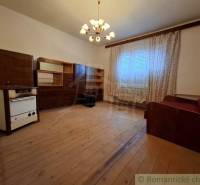 Living room in a family house with wooden decor, curtains, and a sofa.