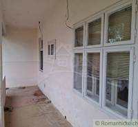 A family house in Mužla with a walkthrough terrace, windows with blinds, and a concrete floor.