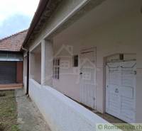 A family house in Mužla with a white facade and a sloped roof made of red tiles.