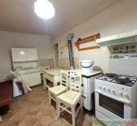 A kitchen in a family house with a gas stove and wooden furniture.