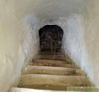 Stone stairs leading to the basement in a family house, walls with thick plaster.