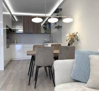 A bright kitchen with a dining table in a two-room apartment with a wooden decor floor.
