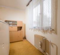 A room in a family house with older furniture, a radiator, and a carpet.