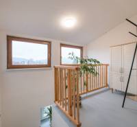 Windows with wooden frames, railing, plant, white furniture in a 2-room apartment.