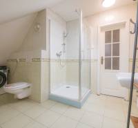 Bathroom in a 2-room apartment with a washing machine, toilet, and shower.