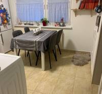 Dining area in a 2-room apartment with a white table and gray chairs.