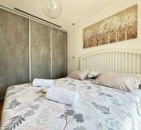 A bright bedroom in a villa with a large bed and a painting above the headboard.