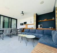 Spacious interior of a villa with stone elements and comfortable seating.