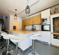 A modern kitchen with an island and bar stools in the villa.