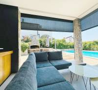 The exterior of the villa in Jakišnica with a swimming pool, seating area, and garden fireplace.