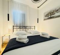 Cozy bedroom in a villa with a black metal bed frame and hanging lamps.