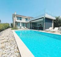 Villa in Jakišnica with a pool and stone terrace, surrounded by greenery.