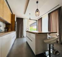 The kitchen area of the villa with stylish lighting and a wooden decor floor.