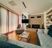 Living room in a villa with a fireplace, TV, wooden decor flooring, and comfortable seating.