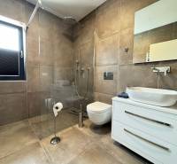A bathroom in a villa with a large shower and a wall-mounted toilet.