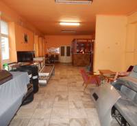 Interior of gastro spaces with orange walls, storage area with chairs and equipment.