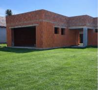 An unfinished family house in Dolná Seč with a grassy plot and brick foundations.