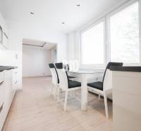 A kitchen in a 3-room apartment with a dining table and a wooden decor floor.