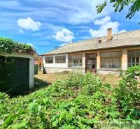 The back side of the cottage in Kamenný Most with a garden and blue sky.