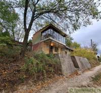 A cottage in Kamenín surrounded by nature, trees, and a path.