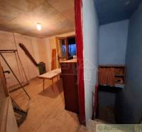 Interior of a cabin with a wood-patterned floor, hallway, and table.
