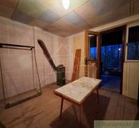 The interior of a cabin with a wooden decor floor and old furniture.