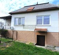A family house in Hráň with a grassy yard, windows, and entrance doors.