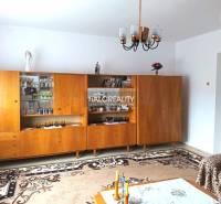 Living room in a family house with a wooden wall unit and a chandelier.