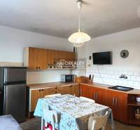 A kitchen in a family house with wooden kitchen furniture and a dining table.