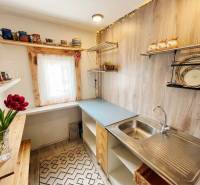 A kitchen in a family house with shelves and a wooden decor floor.