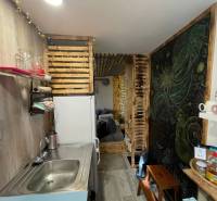 A kitchen corner with wooden decorations and shelves, a floor with a wooden decor.