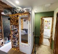 Interior of a family house with illuminated decorations, a mirror, and photos on the wall.
