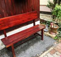 A wooden bench with a plant and decorative ornament at a family house in Bohdanovce nad Trnavou.