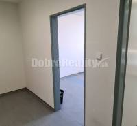 Narrow office spaces with gray flooring and white walls, suitable for work activities.