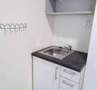 Offices with a cabinet, sink, and shelf, floor with wood decor.