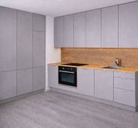 A kitchen with gray cabinets, wooden floor decor, and lighting for a three-room apartment.