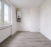 A room with white walls and a wooden decor floor in a 3-room apartment.