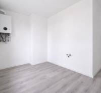 A room with a boiler and a wooden decor floor in a 3-room apartment.
