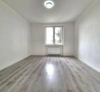 An empty room with wooden floor decor and white walls in a 3-room apartment.