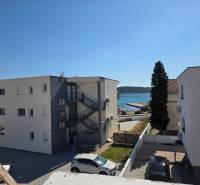 Buildings near the sea in the town of Srima, with a view of the coast and cars in the parking lot.