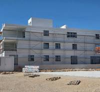 A building in the city of SRIMA with scaffolding and mess on the ground.