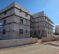 A construction project of a 3-room apartment in SRIMA, surrounded by scaffolding in sunny weather.