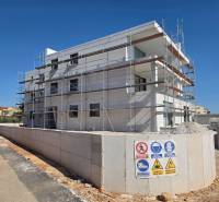 A building with scaffolding in SRIME, a 3-room apartment under construction.