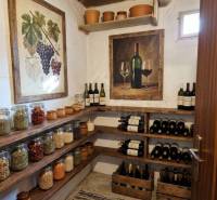A pantry in a family house with wine shelves and food jars.