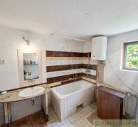 A bathroom in a family house with a sink, a bathtub, and a boiler.
